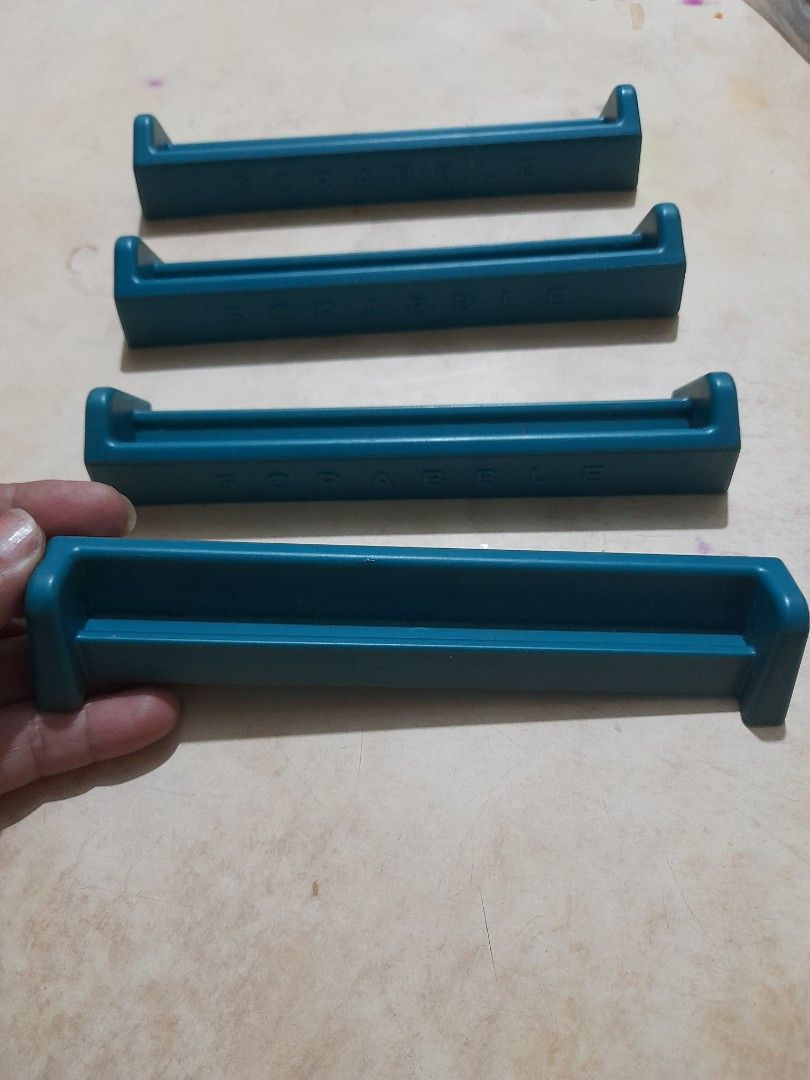 Set of 4 Scrabble Tile Racks (Category: Board Games & Puzzles) located in Bocaue. Submitted by marajapansurplus (Listing ID 1466068557, Image 3). Description: - Set of 4 blue Scrabble tile racks - Great as replacement pieces or extra holders for game night - Made of durable molded plastic with raised branding on the back - Clean condition with no major marks.