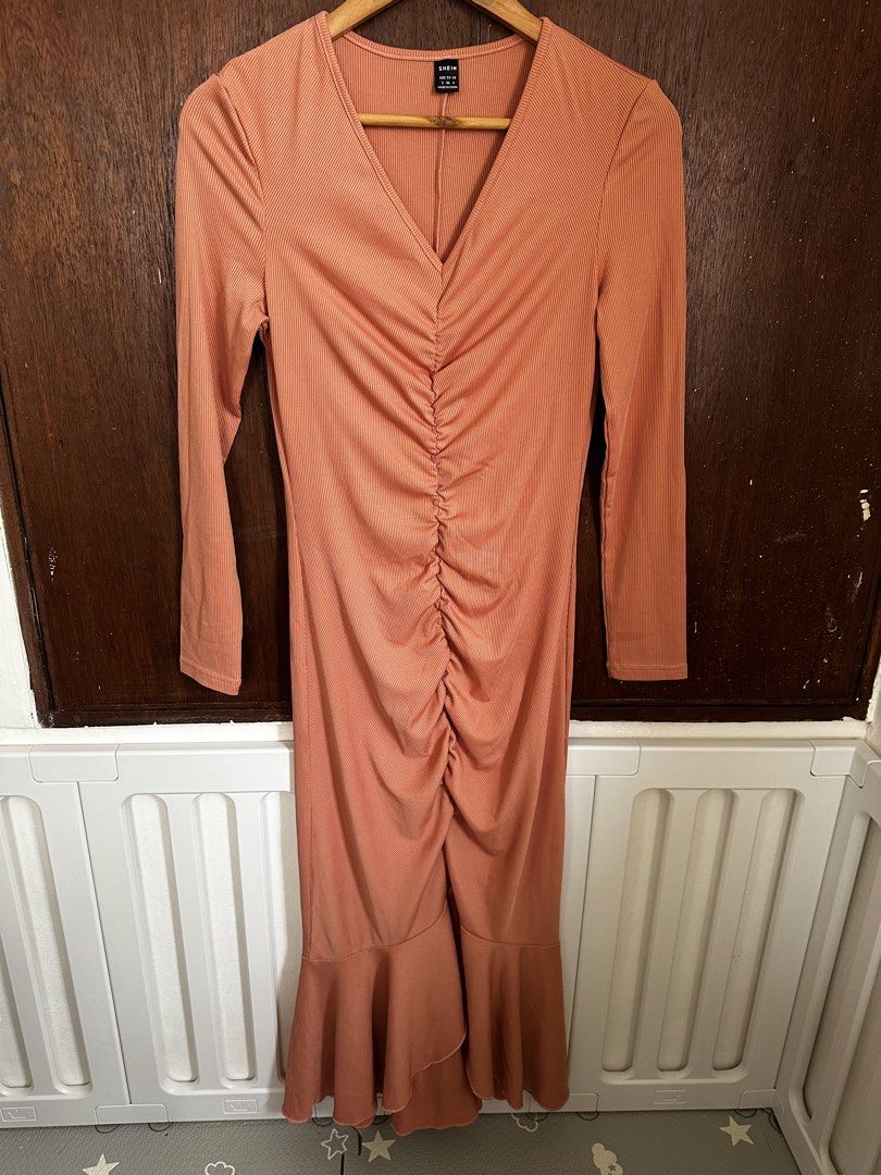 SHEIN Ribbed Ruched V-Neck Maxi Dress Peach (Category: Dresses) located in Manila. Submitted by annika.rrl (Listing ID 1466016830, Image 2). Description: - Brand: SHEIN - Color: Peach - Style: Long sleeve V-neck ribbed maxi dress - Design details: Ruched center front with a flared mermaid hem - Fit: Stretchy material for a comfortable fit - Back: Plain with a straight hemline.