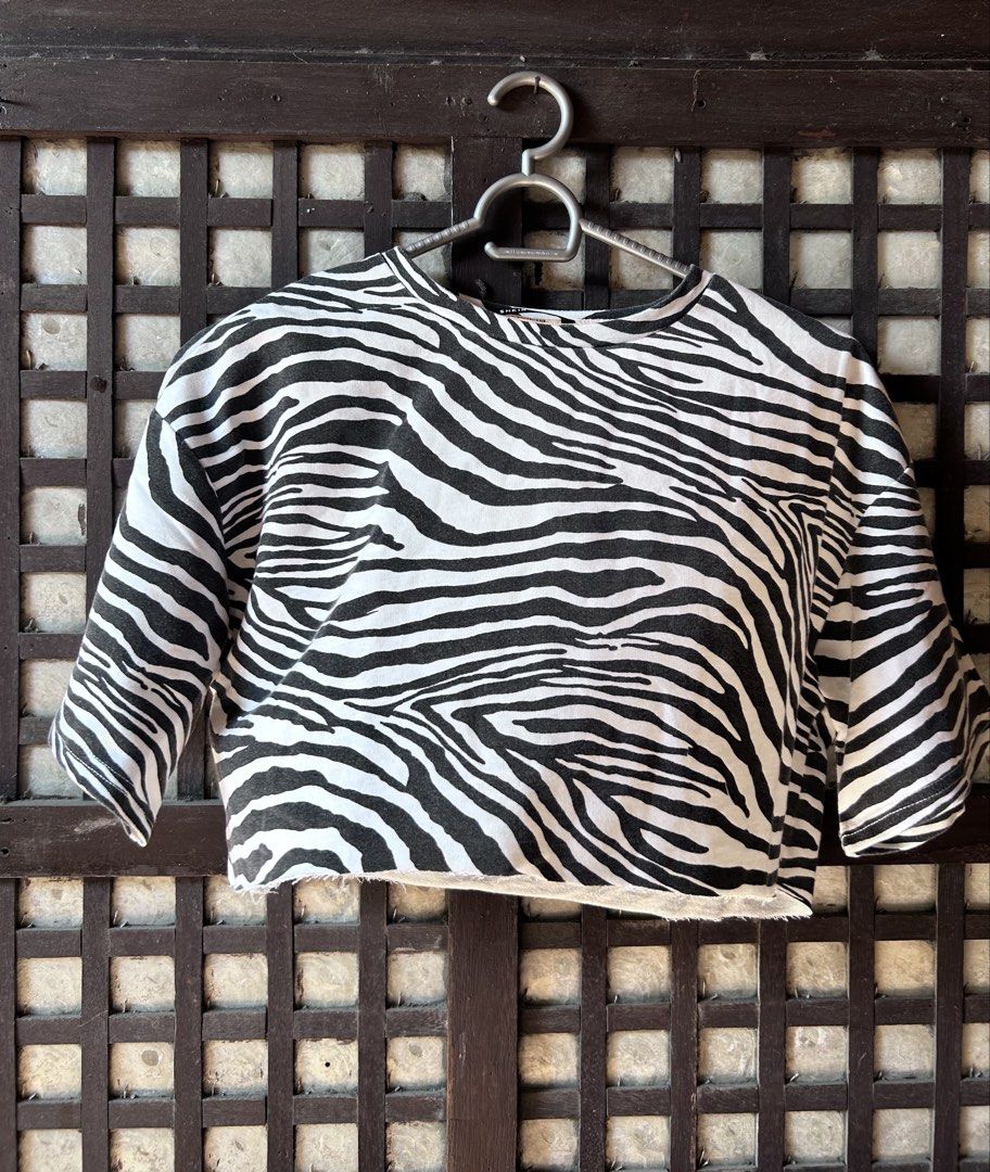 SHEIN Zebra Print Crop Top (Category: Sleeveless) located in Makati City. Submitted by hzsans92 (Listing ID 1466104504, Image 1). Description: - Brand: SHEIN - Design: Black and white zebra print crop top - Fit: Boxy cut with crew neck and mid-length sleeves - Detail: Trendy raw hem - Condition: Worn a few times, still in solid shape - Styling: Easy to match with high-waisted jeans or skirts.