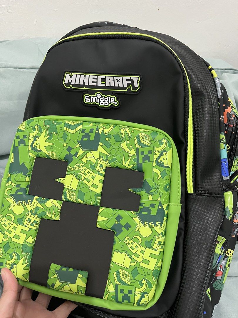 Smiggle Minecraft Classic Backpack (Category: Backpacks) located in Taguig. Submitted by m.listings (Listing ID 1466155710, Image 2). Description: - Authentic Smiggle x Minecraft collaboration classic backpack - Sleek black base featuring a striking green Creeper graphic on the front pocket - Fun all-over pixelated character print on the straps and sides - Premium Minecraft and Smiggle rubber badges on the front - Practical internal slip pocket a