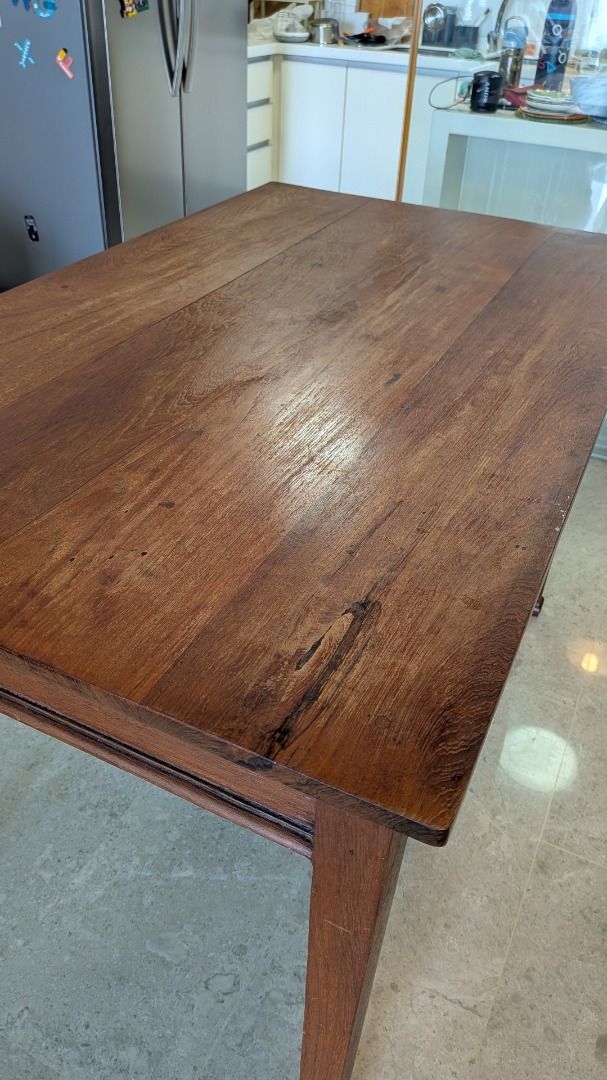 Solid Wood Dining Table (Category: Tables & Sets) located in Singapore. Submitted by haanbun (Listing ID 1465969557, Image 3). Description: - Material: Solid wood with natural grain patterns and knots - Design: Sturdy rectangular top with tapered legs and rich brown finish - Condition: Minor wear on the leg base from daily use - Dimensions: 120cm x 73 x 77 *Decorated for illustration only. Decor not included*.