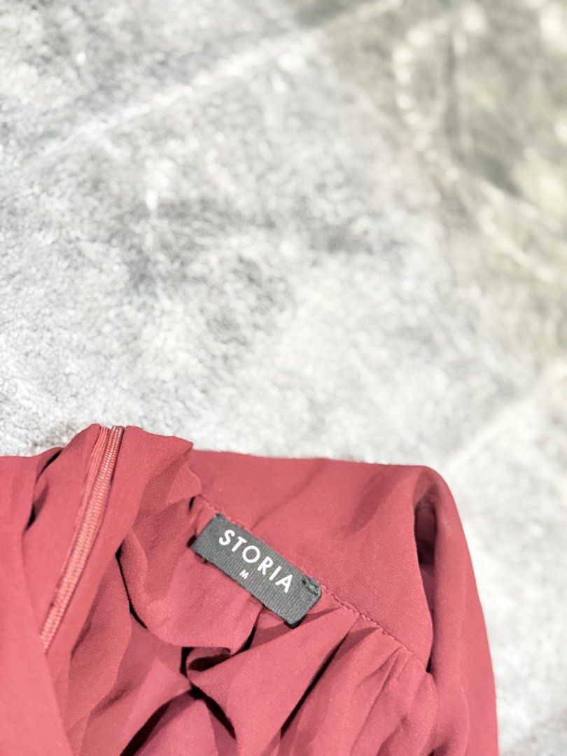 STORIA Maroon Ruffle Mini Dress Size M (Category: Dresses) located in Manila. Submitted by yeti_it (Listing ID 1466061678, Image 2). Description: - Brand: STORIA - Size: Medium - Color: Maroon / Burgundy - Style: Mini dress with deep V-neckline, ruffled shoulder straps, and flared skirt with ruffled hem - Material: Lightweight chiffon-like fabric with pleated bodice details - Closure: Side zipper - Occasion: Perfect for dates, parties, and night 