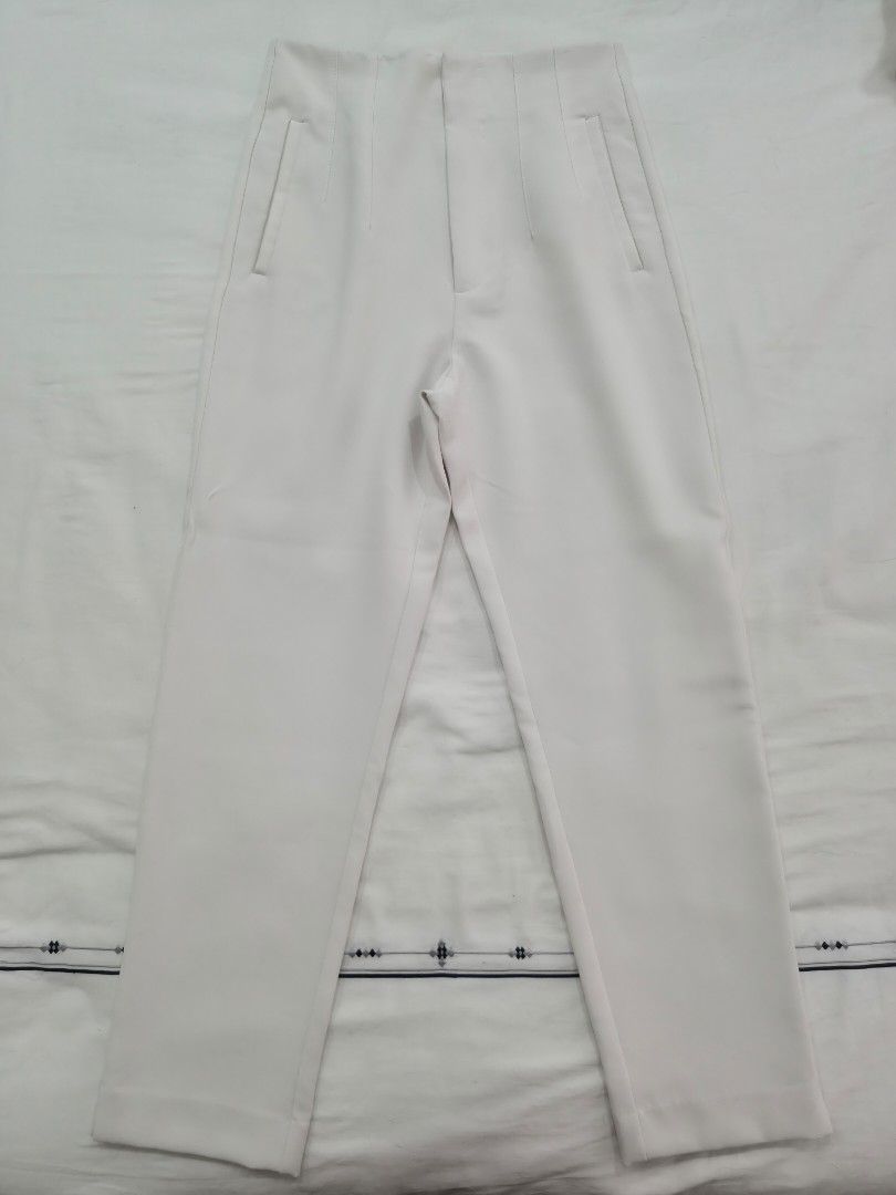 Stradivarius White High-Waisted Tailored Pants (Category: Jeans) located in Quezon City. Submitted by corrnic (Listing ID 1466062616, Image 2). Description: - Color: Crisp white - Style: High-waisted with stitched front pleats and slim, ankle-tapered fit - Details: Structured waistband and functional welt hip pockets - Versatility: Perfect for workwear or weekend outings - Measurements (approx. flat lay): Waist 13 inches, Hips 19 inches - Conditi