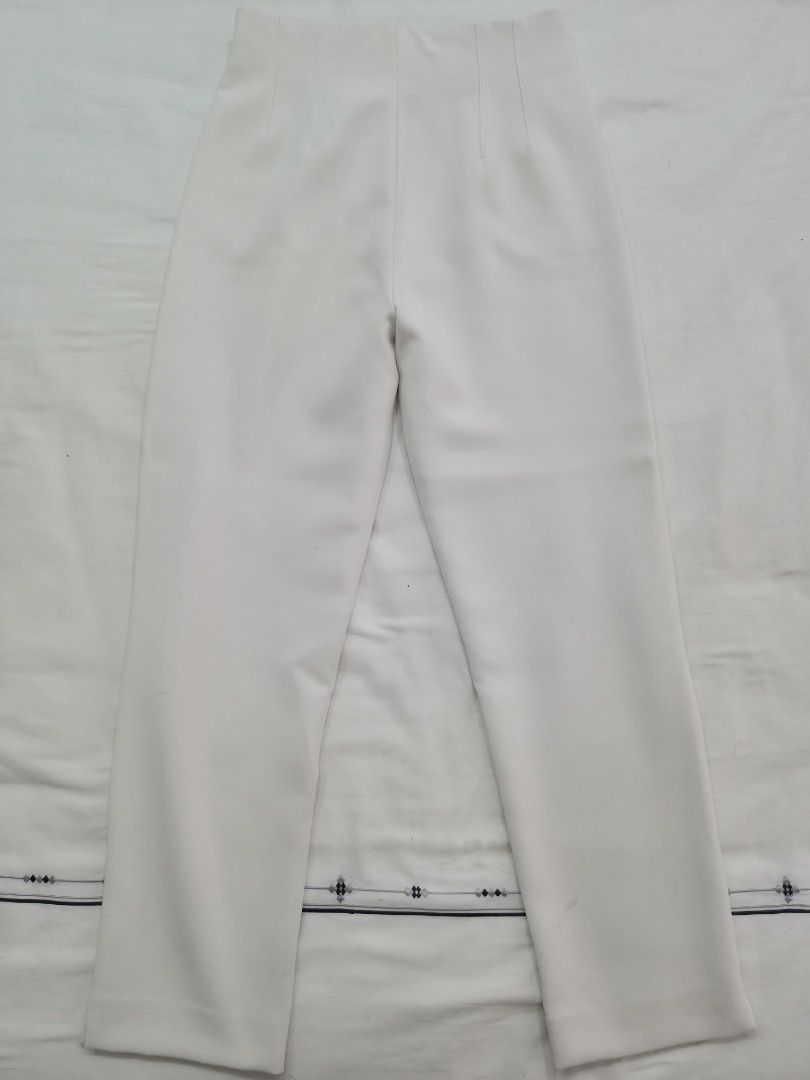 Stradivarius White High-Waisted Tailored Pants (Category: Jeans) located in Quezon City. Submitted by corrnic (Listing ID 1466062616, Image 3). Description: - Color: Crisp white - Style: High-waisted with stitched front pleats and slim, ankle-tapered fit - Details: Structured waistband and functional welt hip pockets - Versatility: Perfect for workwear or weekend outings - Measurements (approx. flat lay): Waist 13 inches, Hips 19 inches - Conditi