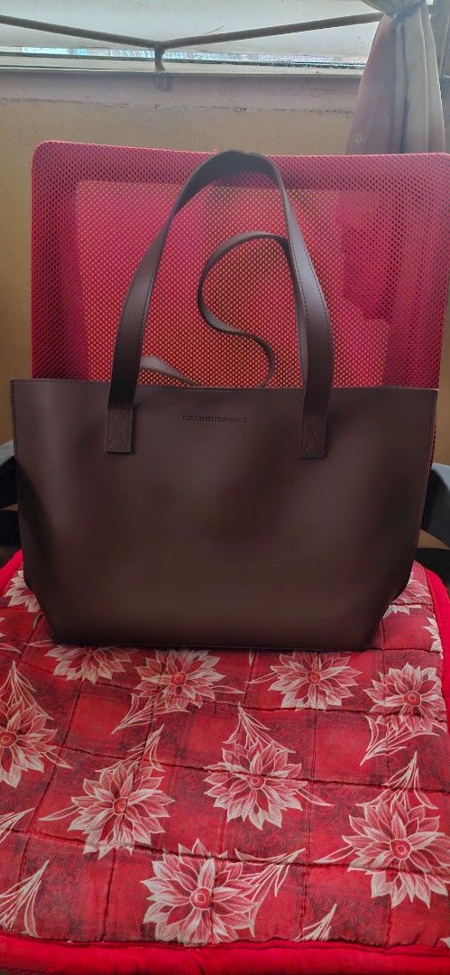 Straightforward Brown Leather Tote Bag (Category: Tote Bags) located in Quezon City. Submitted by gnelsky (Listing ID 1465994110, Image 1). Description: - Color: Brown - Material & Interior: Sturdy exterior with a spacious tan suede lining - Closure: Secure magnetic button closure - Features: Minimal front branding, double handle straps, and a convenient internal slip pocket - Condition: Clean interior, well-maintained - Best for: Everyday use fo