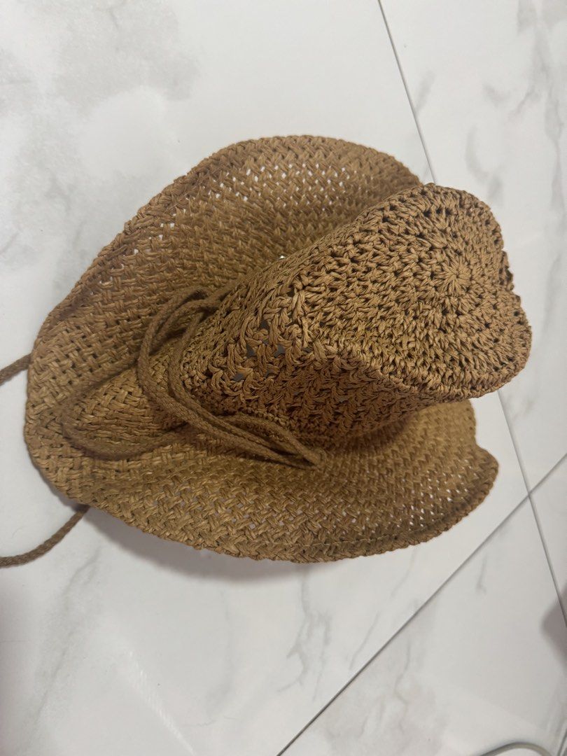 Straw Cowboy Hat Brown Beach Sun Hat (Category: Others Tops) located in Manila. Submitted by decluterthings888 (Listing ID 1465956709, Image 3). Description: - Style: Classic western shape with curved brim sides - Material: 100% paper (woven straw design with open ventilation holes) - Features: Matching braided chin strap with tassels - Best for: Beach trips, sunny days, and outdoor events - Condition: Good quality.