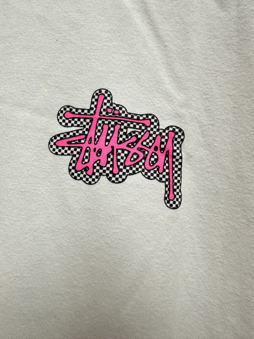 Stüssy Checkerboard Graphic Tee White Pink L (Authentic) (Category: Tshirts & Polo Shirts ) located in Manila. Submitted by ylsrarities (Listing ID 1465992169, Image 2). Description: • Made in Mexico • Size Large • Measurements: 22Wx28L • “NEW YORK LOS ANGELES LONDON PARIS TOKYO” text • Original Stüssy neck and care labels • RN 94974 / CA 28629 • Guaranteed Legit/Authentic, Money back if proven fake Condition: 8/10 Pre-owned with normal signs of 