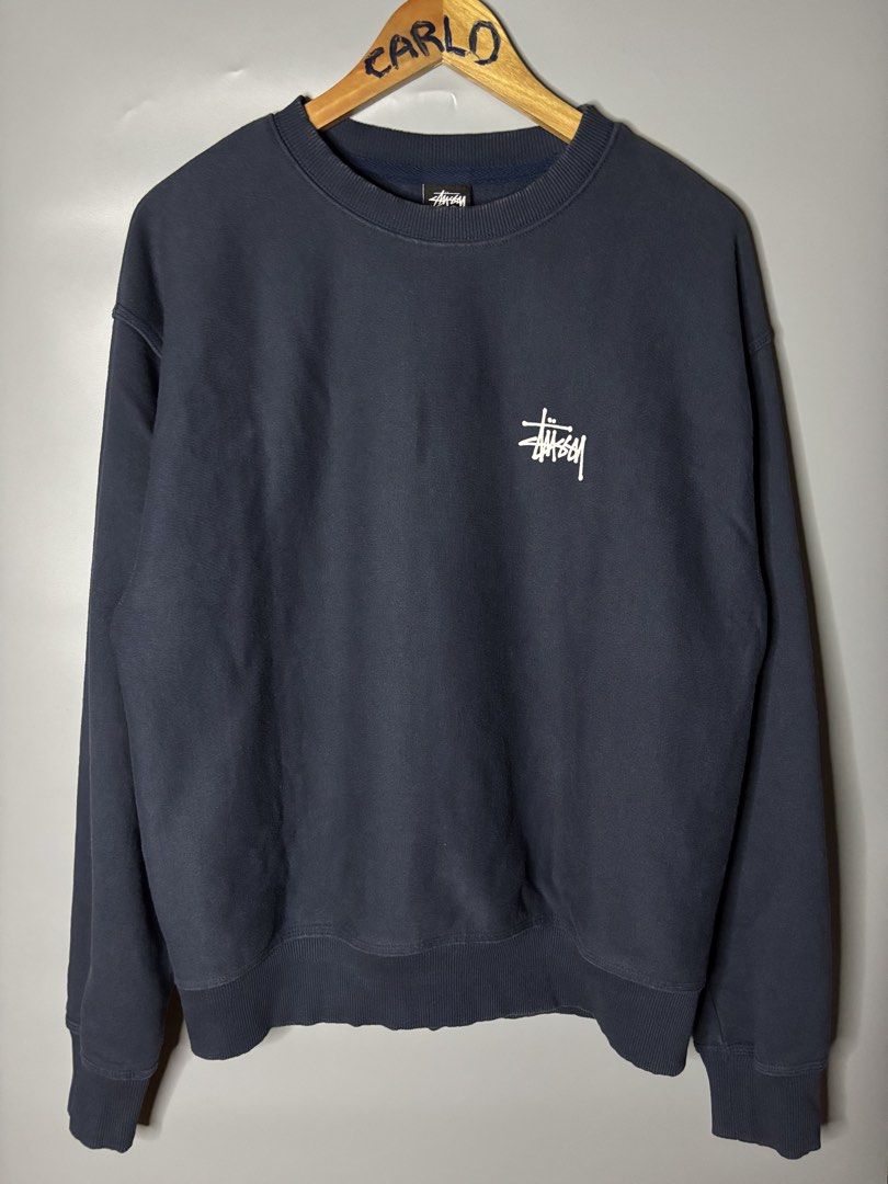 STUSSY BASIC LOGO CREWNECK (Category: Coats, Jackets and Outerwear) located in Bayambang. Submitted by lo_keythrifting (Listing ID 1465993065, Image 1). Description: - Brand: Stussy - Condition: Excellent condition - Dimes: 23*26.5 - Color rate: 9.8/10 - Issue: Minimal Oil stain see last pic - Style: Crewneck sweatshirt - Color: Dark navy blue - Size: Medium - Details: Small white chest logo, giant logo printed across the back - Material: 70% cot