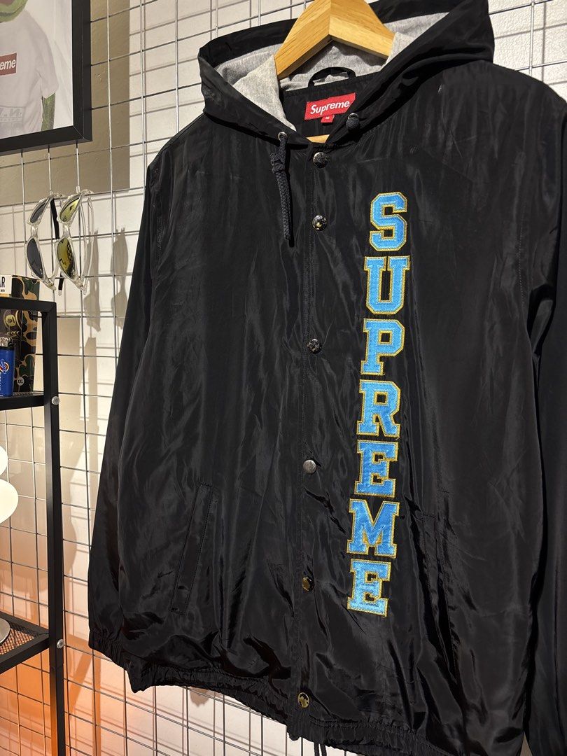 Supreme Hooded Coaches Jacket Black Size M (Category: Coats, Jackets and Outerwear) located in Cavite. Submitted by vlblgrmnts_ (Listing ID 1466067664, Image 3). Description: Supreme - P268 22x28 Bestfit Large 9/10 CR 1800 - Brand: Supreme - Style: Hooded Coaches Jacket - Color: Black with blue/yellow embroidered 'SUPREME' lettering - Size: Medium (red collar label) - Details: Grey heather hood lining with drawstring, snap button closure, elastic