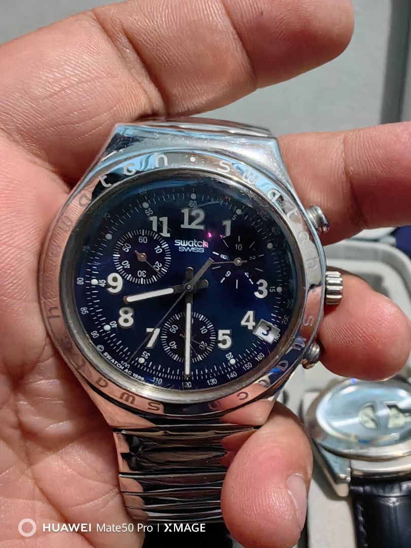 Swatch Swiss Chronograph Metal Watch (Category: Men's Watches) located in Manila. Submitted by lucky_yonathan (Listing ID 1466079365, Image 1). Description: - Brand: Swatch Chronograph Watch - Material: Stainless steel case and silver-tone metal bracelet with flexible links - Dial: Deep blue with 3 sub-dials and date window at 4 o'clock - Details: Bezel engraved with Swatch branding - Condition: Fully functional and keeps time properly, with visi