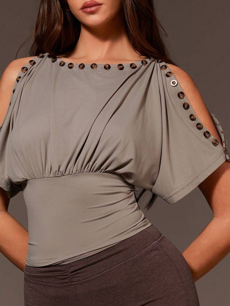 Taupe Cold Shoulder Button Detail Top Size M (Category: Blouses) located in Quezon City. Submitted by getitrightaway.ph (Listing ID 1466063361, Image 1). Description: - Color: Taupe Grey - Size: M (Made in China) - Design: Cold shoulder cutouts with chic tortoiseshell buttons - Fit: Fitted waist with gentle gathering and short dolman sleeves - Versatility: Neutral tone, super easy to pair with shorts or denim - Condition: Excellent/unworn (flat l