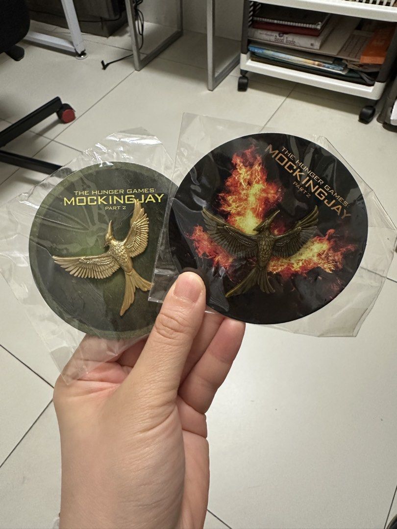 The Hunger Games Mockingjay Part 2 Pin Badge (Category: Western Merchandise) located in Paranaque City. Submitted by elenyuloque (Listing ID 1466018761, Image 2). Description: - Set of 2 Hunger Games Mockingjay Part 2 pins - Includes 1 gold bird on green backing and 1 dark bird against flames - Comes with original circular movie-branded backing cards - Brand new and unopened in original plastic packaging - Great addition for any fan or collector.