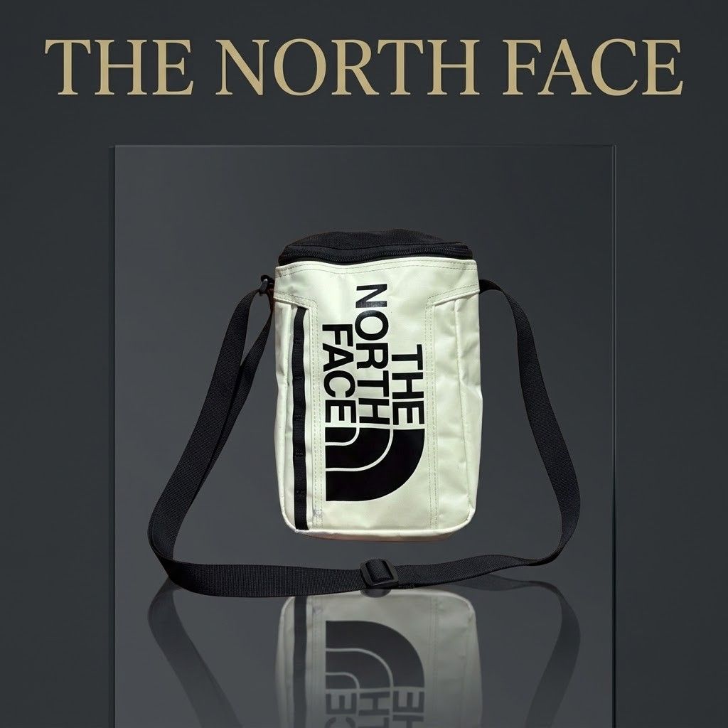The North Face Crossbody Bag (Category: Sling Bags) located in Carmen. Submitted by ar_thrift00 (Listing ID 1466084642, Image 1). Description: - Brand: The North Face - Color: Off-white with bold black front logo - Features: Adjustable black strap, top zipper closure, vertical front daisy chain webbing - Condition: Good overall, but has minor colored ink/dye stains on the side and back panels (fabric otherwise clean) - Perfect for casual streetwe