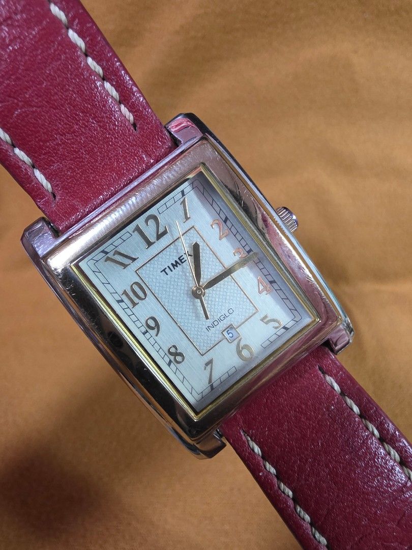 Timex Indiglo Rectangular Watch with Red Leather Strap (Category: Men's Watches) located in Rosales. Submitted by akumie30 (Listing ID 1466137194, Image 3). Description: - Brand: Timex - Case: Rectangular gold-tone with stainless steel back - Dial: Textured silver with date display at 6 o'clock - Lighting: Indiglo night-light feature - Strap: Genuine red leather with white contrast stitching - Battery: Uses CR 1216 cell battery Original Watch Wor