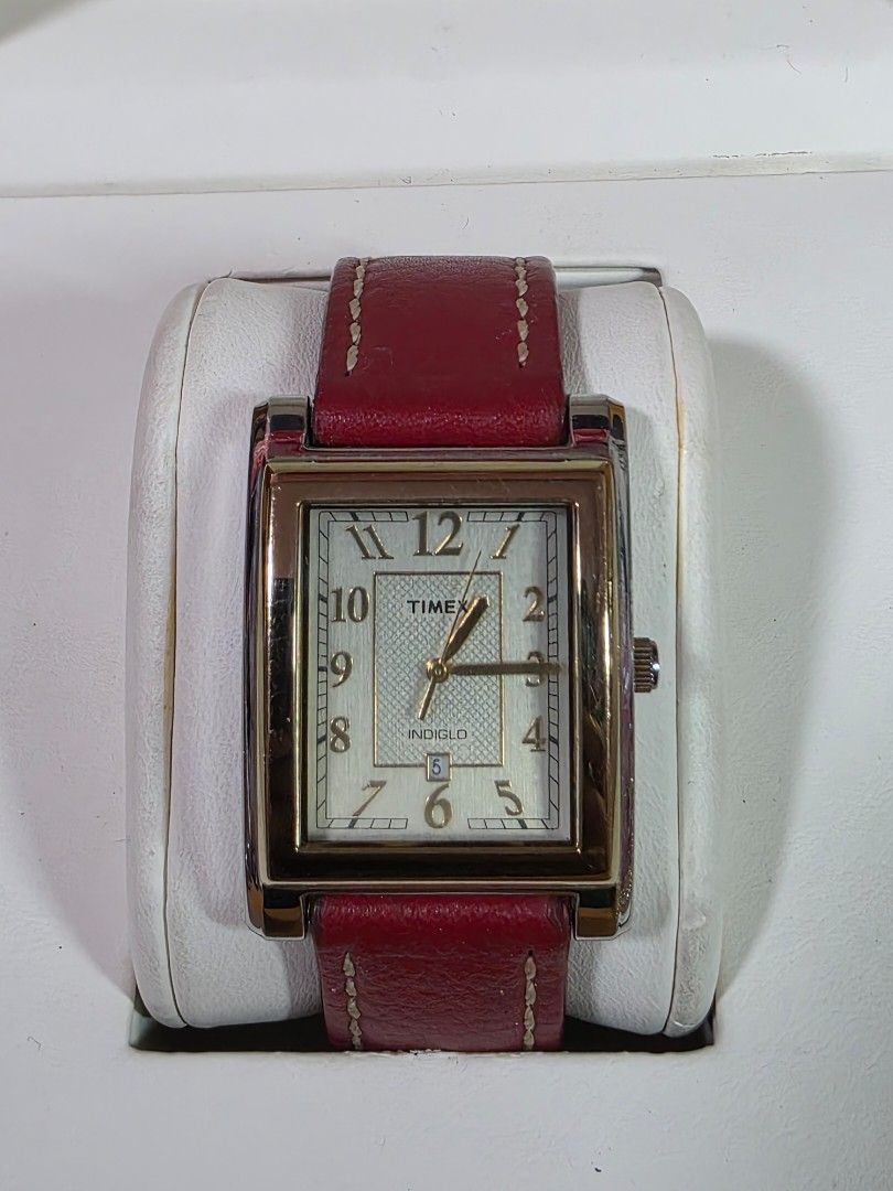 Timex Indiglo Rectangular Watch with Red Leather Strap (Category: Men's Watches) located in Rosales. Submitted by akumie30 (Listing ID 1466137194, Image 1). Description: - Brand: Timex - Case: Rectangular gold-tone with stainless steel back - Dial: Textured silver with date display at 6 o'clock - Lighting: Indiglo night-light feature - Strap: Genuine red leather with white contrast stitching - Battery: Uses CR 1216 cell battery Original Watch Wor