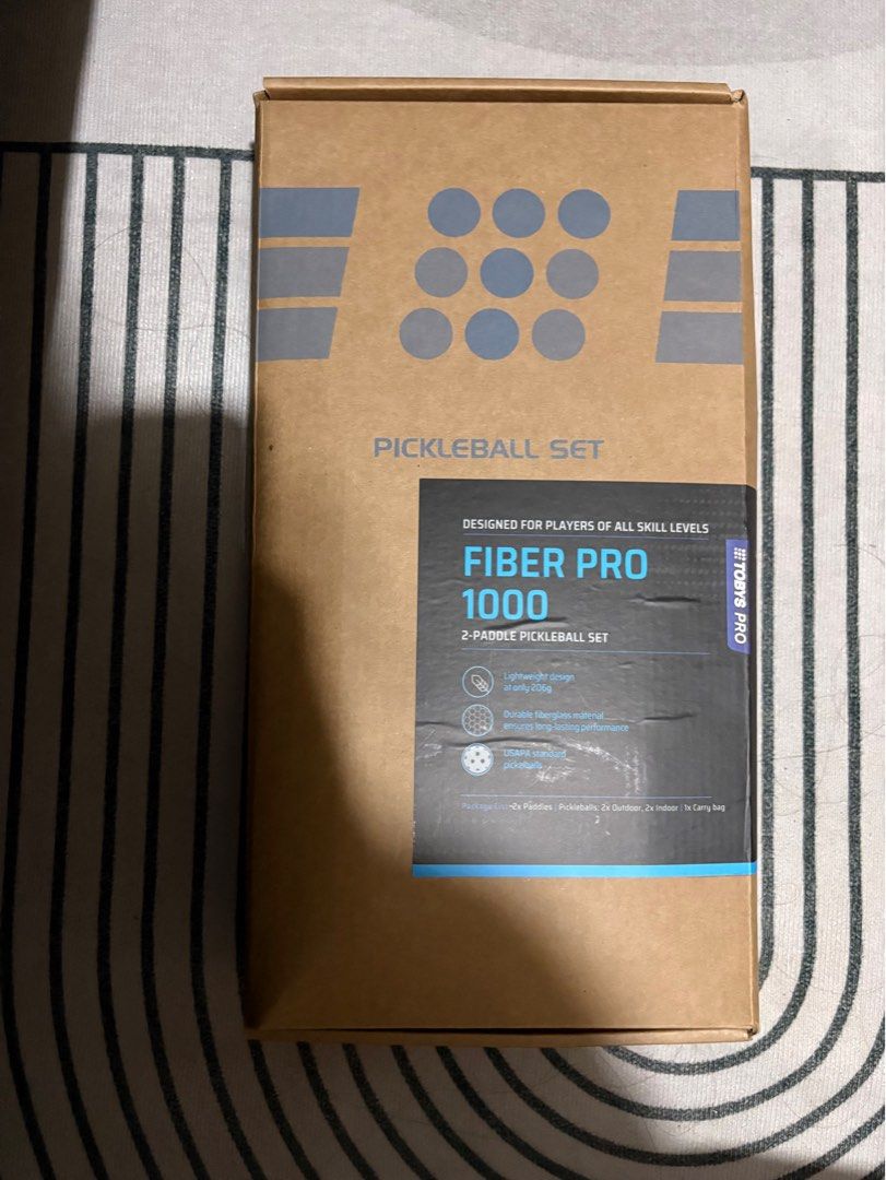 Tobys Pro Fiber Pro 1000 Pickleball Set (Category: Racket and Ball Sports) located in Plaridel. Submitted by thefatbearinside (Listing ID 1466042183, Image 2). Description: - Brand/Model: Tobys Pro Fiber Pro 1000 Pickleball Set - Paddle Weight: Ultra-lightweight at 206g each for effortless swings - Material: Durable fiberglass face with USAPA standard pickleballs - Design: Eye-catching geometric pattern in blue, orange, black, and green - Complet