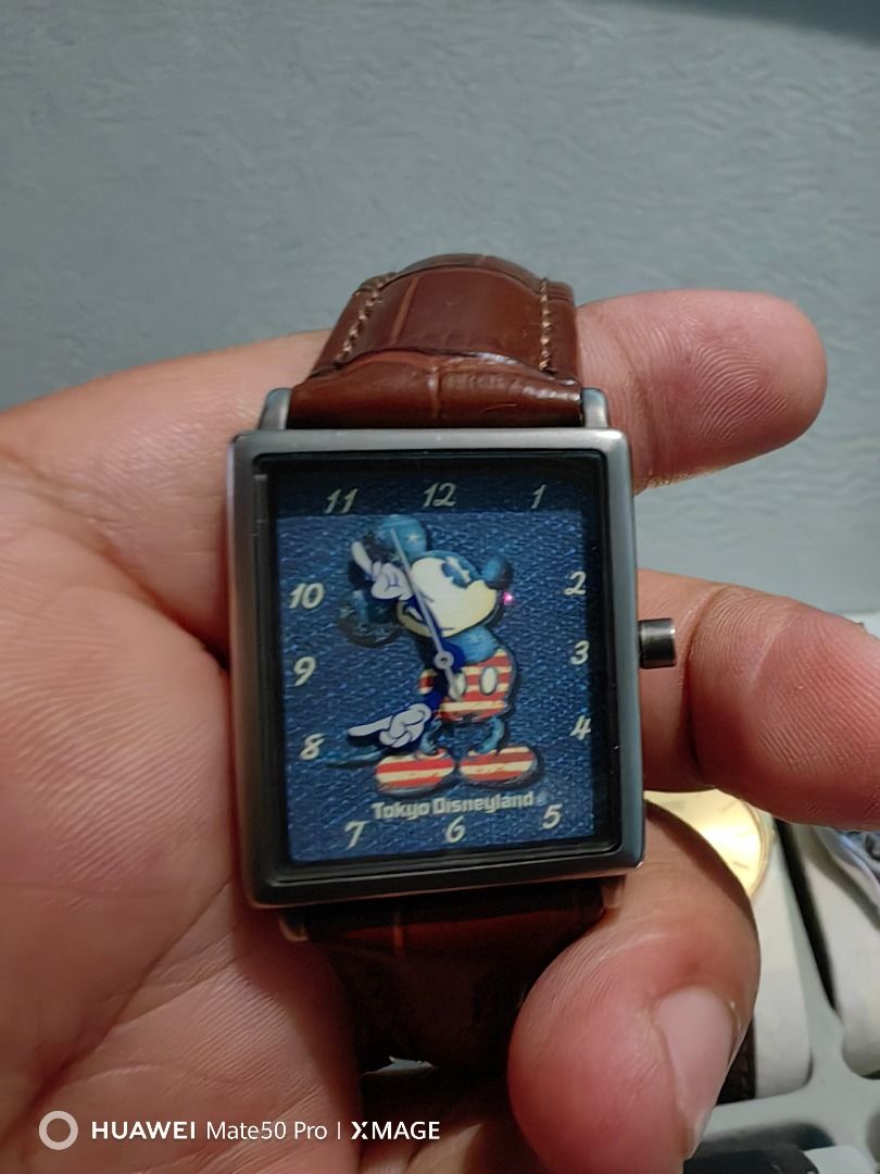 Tokyo Disneyland Mickey Mouse Watch Rectangular Case Brown Leather Strap (Category: Men's Watches) located in Manila. Submitted by lucky_yonathan (Listing ID 1466075189, Image 3). Description: - Authentic Tokyo Disneyland merchandise featuring a charming Mickey Mouse blue dial - Rectangular metal case paired with a stylish brown faux-croco leather strap - Clear numbers around the face for easy reading - Official Tokyo Disney Resort logo engraved 