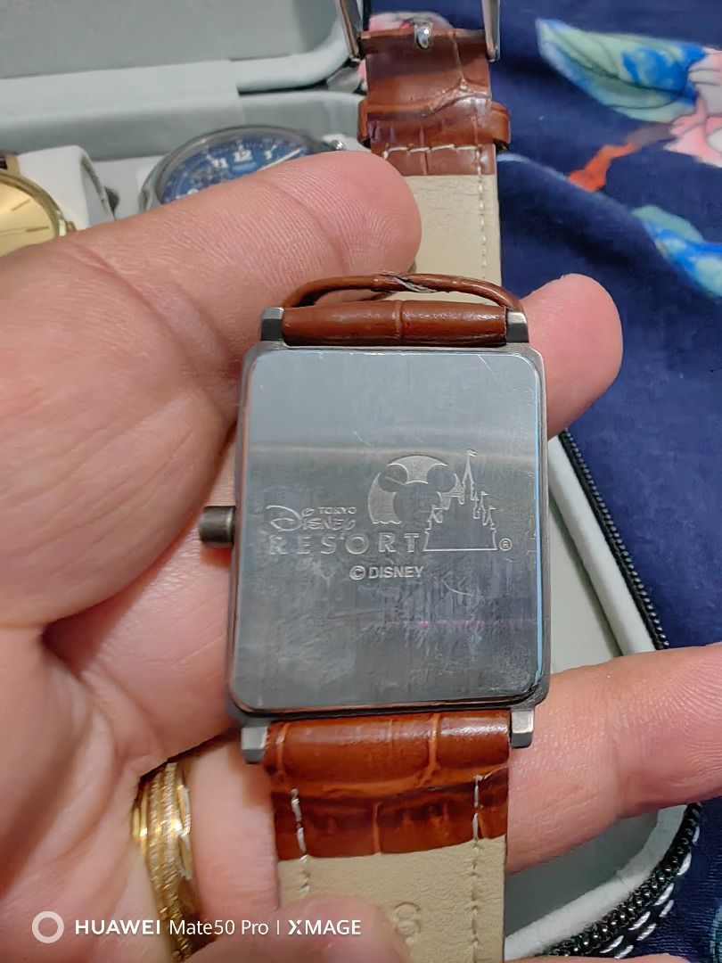 Tokyo Disneyland Mickey Mouse Watch Rectangular Case Brown Leather Strap (Category: Men's Watches) located in Manila. Submitted by lucky_yonathan (Listing ID 1466075189, Image 2). Description: - Authentic Tokyo Disneyland merchandise featuring a charming Mickey Mouse blue dial - Rectangular metal case paired with a stylish brown faux-croco leather strap - Clear numbers around the face for easy reading - Official Tokyo Disney Resort logo engraved 