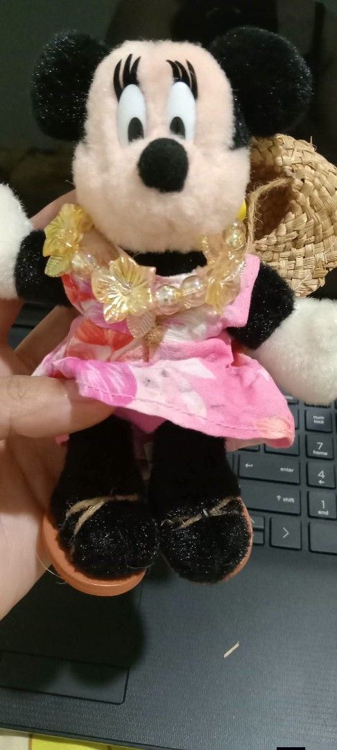Tokyo Disneyland Minnie Mouse (Category: Plushies & Soft Toys) located in Gapan. Submitted by montesnora80204 (Listing ID 1466095847, Image 3). Description: - Authentic Tokyo Disneyland merchandise with original tag attached - Features Minnie Mouse in a pink tropical floral dress, yellow flower lei, and mini straw hat - Hand-held, compact size perfect for display or collecting - Flawless condition: clean plush material with no stains or damage.