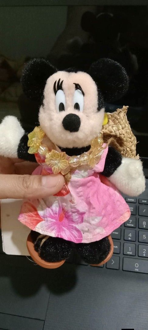 Tokyo Disneyland Minnie Mouse (Category: Plushies & Soft Toys) located in Gapan. Submitted by montesnora80204 (Listing ID 1466095847, Image 1). Description: - Authentic Tokyo Disneyland merchandise with original tag attached - Features Minnie Mouse in a pink tropical floral dress, yellow flower lei, and mini straw hat - Hand-held, compact size perfect for display or collecting - Flawless condition: clean plush material with no stains or damage.