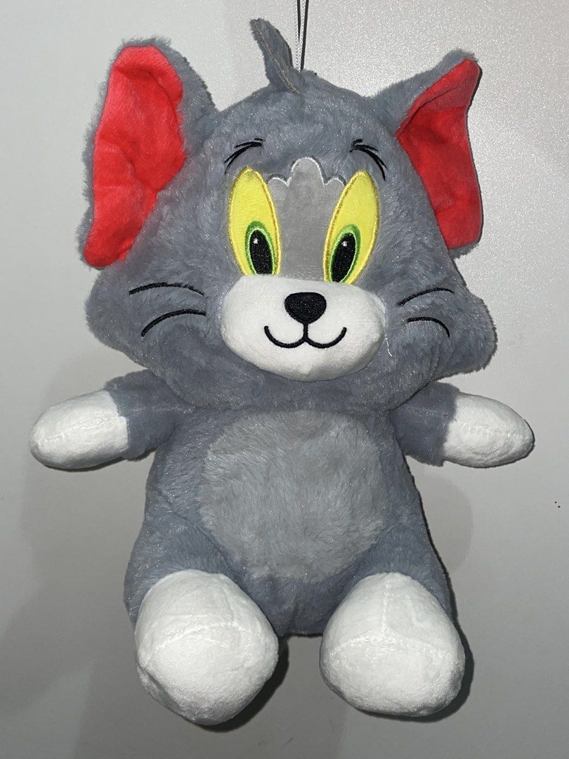 Tom and Jerry Tom Plush Toy (14 inch) (Category: Plushies & Soft Toys) located in Las Pinas. Submitted by picksbycie (Listing ID 1466041265, Image 1). Description: - Character: Tom (Tom and Jerry) - Material: Soft and cuddly plush texture - Design: Grey body with white paws, muzzle, tail tip, bright red inner ears, and yellow embroidered eyes - Features: Includes a hanging string at the top and a functional zipper down the back - Condition: Excel