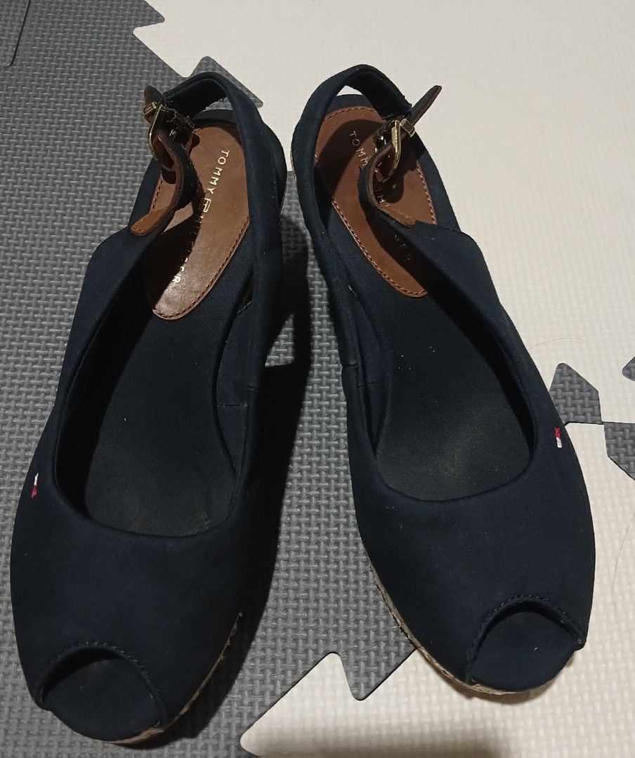 Tommy Hilfiger Navy Blue Wedge Sandals (Category: Sandals) located in Umingan. Submitted by mrobvariety (Listing ID 1465990125, Image 2). Description: - size: UK 3.5 - Brand: Tommy Hilfiger - Style: Open-toe wedge sandals with slingback strap and buckle closure - Color/Material: Navy blue canvas upper with dark brown leather details and woven jute platform - Details: Signature embroidered Tommy flag logo on the side - Fit/Condition: Comfortable f