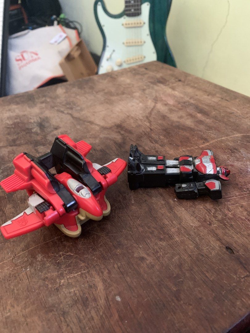 Transformers Armada Thrust Mini-con Inferno 2002 Toy (Category: Action & Battle Toys) located in Makati City. Submitted by emenem.m (Listing ID 1465954104, Image 3). Description: Transformers Armada Thrust figure with accompanying Inferno Mini-con. Red and black color scheme with grey wings and yellow jet thrusters. Rolling wheels underneath. Play-worn condition with minor paint wear across the body. Transforms between robot and jet modes. Sturdy