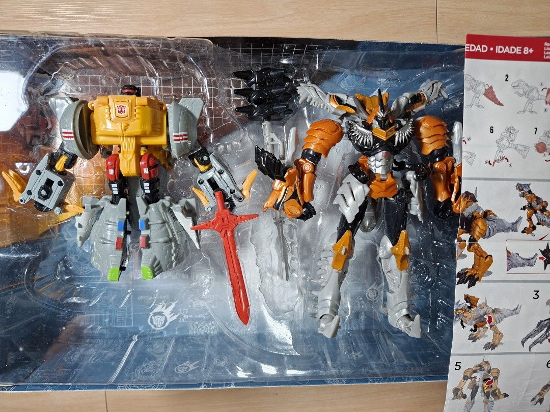 Transformers Evolution 2-Pack Grimlock 1984 & 2014 Toys R Us Exclusive (Category: Action & Battle Toys) located in Baguio. Submitted by restyrille77846 (Listing ID 1465984261, Image 2). Description: - Toys R Us Exclusive Transformers Evolution 2-pack - Features Grimlock from 1984 and 2014 Age of Extinction - Includes original plastic tray packaging, instructions, and red sword accessory - Box shows light shelf wear on the red and white outer pack