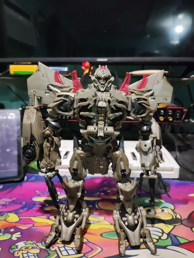 Transformers Movie Leader Class Megatron Action Figure (Category: Figurines & Statues) located in Manila. Submitted by miguelinvictus (Listing ID 1466138022, Image 1). Description: - Character: Megatron (Transformers) - Design: Detailed robot sculpt with grey and tan parts, plus red translucent accents - Articulation: Jointed limbs and torso for & dynamic posing; stands upright on its own - Mode: Fully transforms into vehicle mode - Condition: Ca