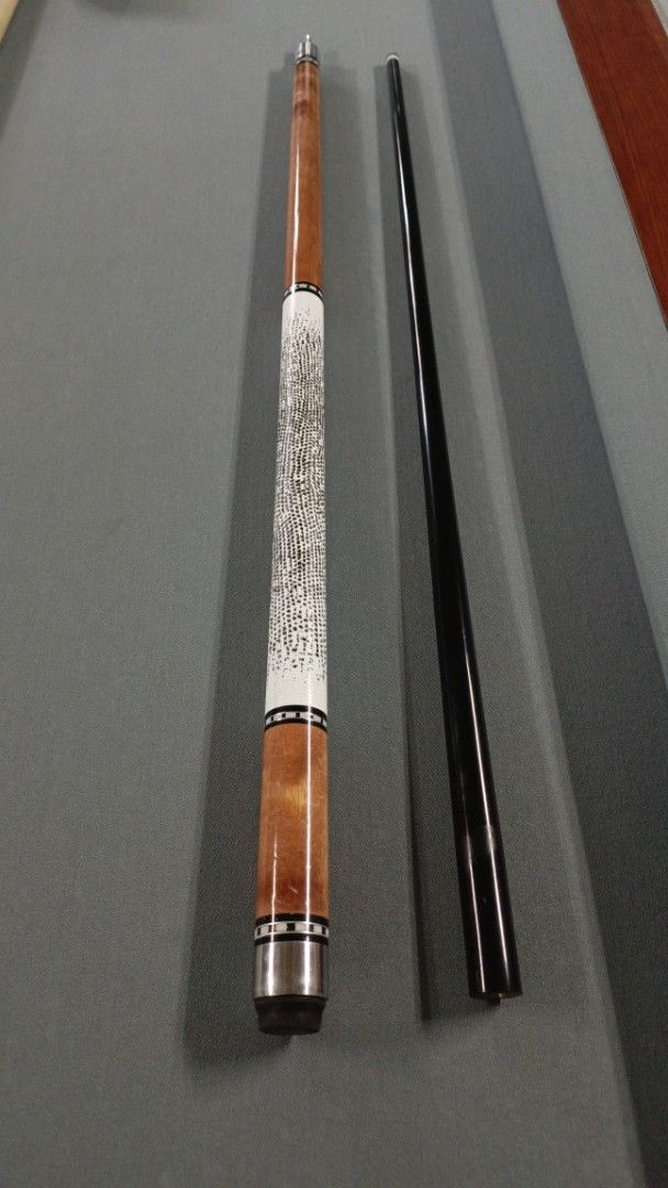 Two-piece billiard pool cue stick with textured grip (Category: Billiards and Bowling) located in Lucban. Submitted by zenlly_rai (Listing ID 1466059891, Image 1). Description: - Type: Standard two-piece pool cue (unscrewed for easy transport) - Design: Wooden forearm and butt section with a detailed textured white grip and black shaft - Performance: Solid weight and straight roll - Condition: Good playing condition with minor scuffs on the woode