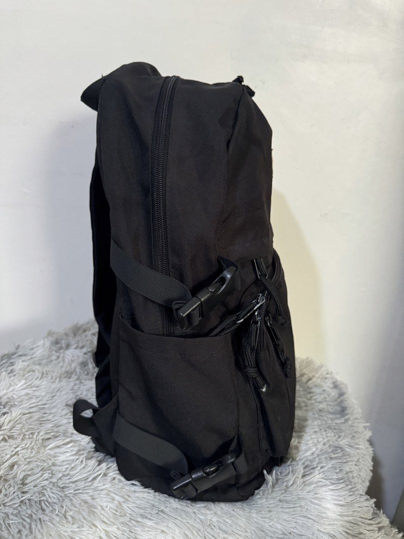 Tyakasha Black Backpack with Front Pocket (Category: Backpacks) located in Urdaneta. Submitted by kathleenja24136 (Listing ID 1465957782, Image 2). Description: - Brand: Tyakasha - Material: Durable black canvas with sturdy hardware - Compartments: Roomy main compartment and front utility pocket with zipper closures and pull cords - Straps: Adjustable padded shoulder straps with D-rings - Features: Side compression straps with plastic buckles and