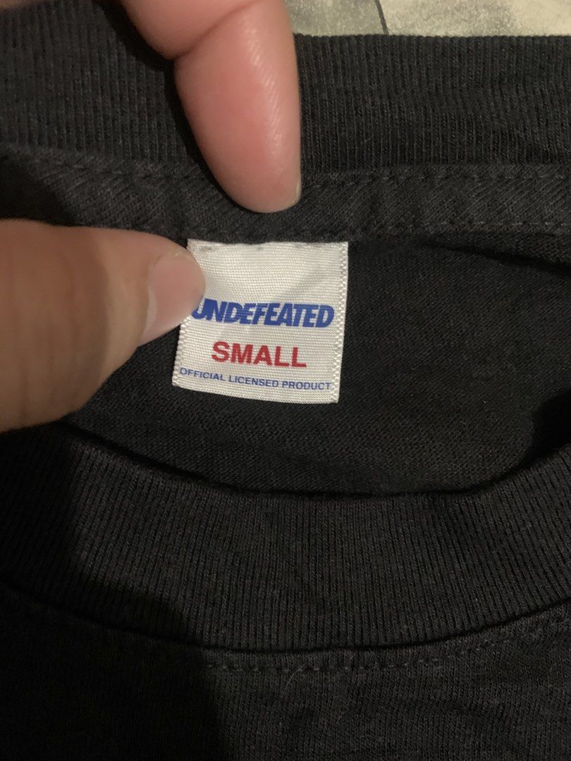 Undefeated Black Long Sleeve T-Shirt (Category: Tshirts & Polo Shirts ) located in Cebu City. Submitted by tangubrhia45277 (Listing ID 1466082349, Image 3). Description: - Brand: Undefeated - Item: Black long sleeve t-shirt with crew neck - Details: Blue and white logo text printed down both sleeves - Size: Small - Origin: Made in USA (Official licensed product tag included) - Condition: Clean fabric, well-maintained.
