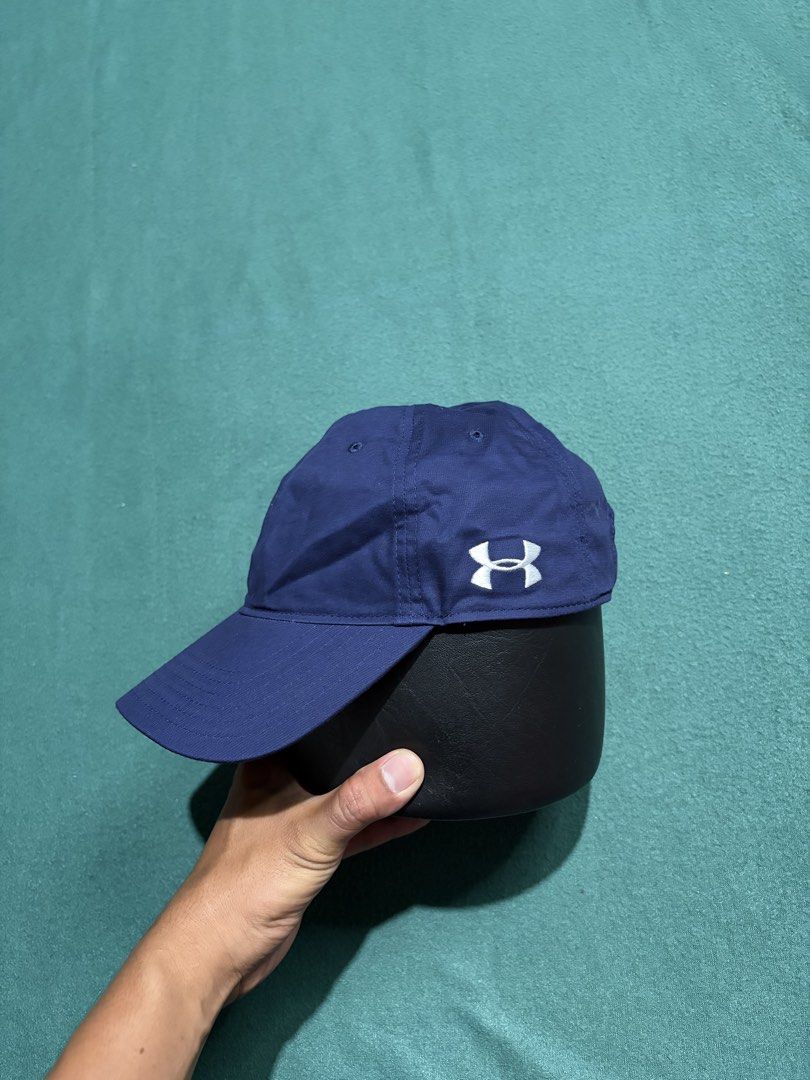 Under Armour Navy Blue Baseball Cap Hat (Category: Caps & Hats) located in Guihulngan. Submitted by fbthriftgoodsniace (Listing ID 1466014163, Image 1). Description: - Brand: Under Armour - Color: Classic Navy Blue - Design: 6-panel structure with embroidered white logo on the side - Brim: Clean, curved design - Closure: Adjustable strapback with silver metal hardware - Condition: Brand new / Excellent - Best for: Gym workouts, sports, or everyda