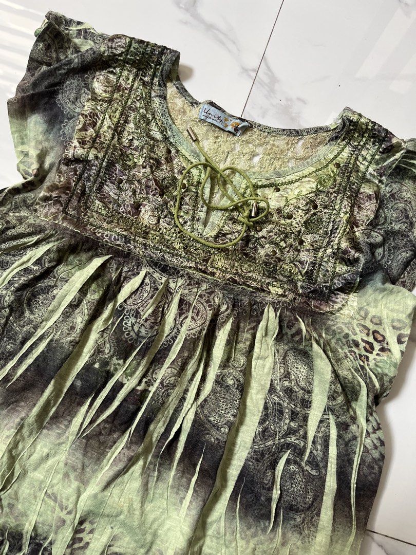 Unity World Wear Green Boho Print Blouse Top (Category: Blouses) located in Caloocan City. Submitted by crucifiedtearz (Listing ID 1466010324, Image 2). Description: - Brand: Unity World Wear - Style: Boho green and black blouse - Details: Intricate paisley & animal prints, tie neckline, and chest stud detailing - Fit: Short flutter sleeves and cinched waist design - Fabric: Lightweight, ideal for casual wear and summer outings.