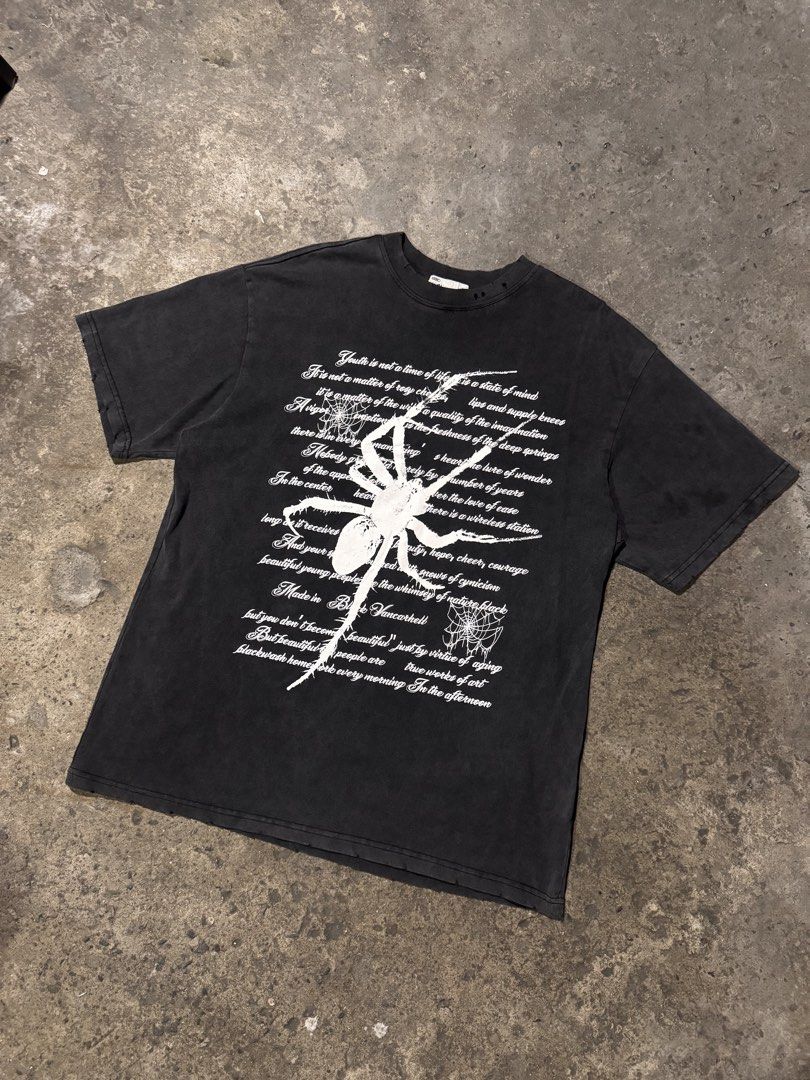 Vancarhell Spider Graphic Distressed T-shirt (Category: Tshirts & Polo Shirts ) located in Pasig City. Submitted by dripthrift1600 (Listing ID 1466098525, Image 1). Description: - Brand: Vancarhell - Size: L - Color: Black with heavy pigment wash - Material: 100% thick, sturdy cotton - Design: Large white spider graphic with typewriter-style text and spiderweb details - Details: Distressed holes on the collar ribbing for a vintage, worn-in aesthe