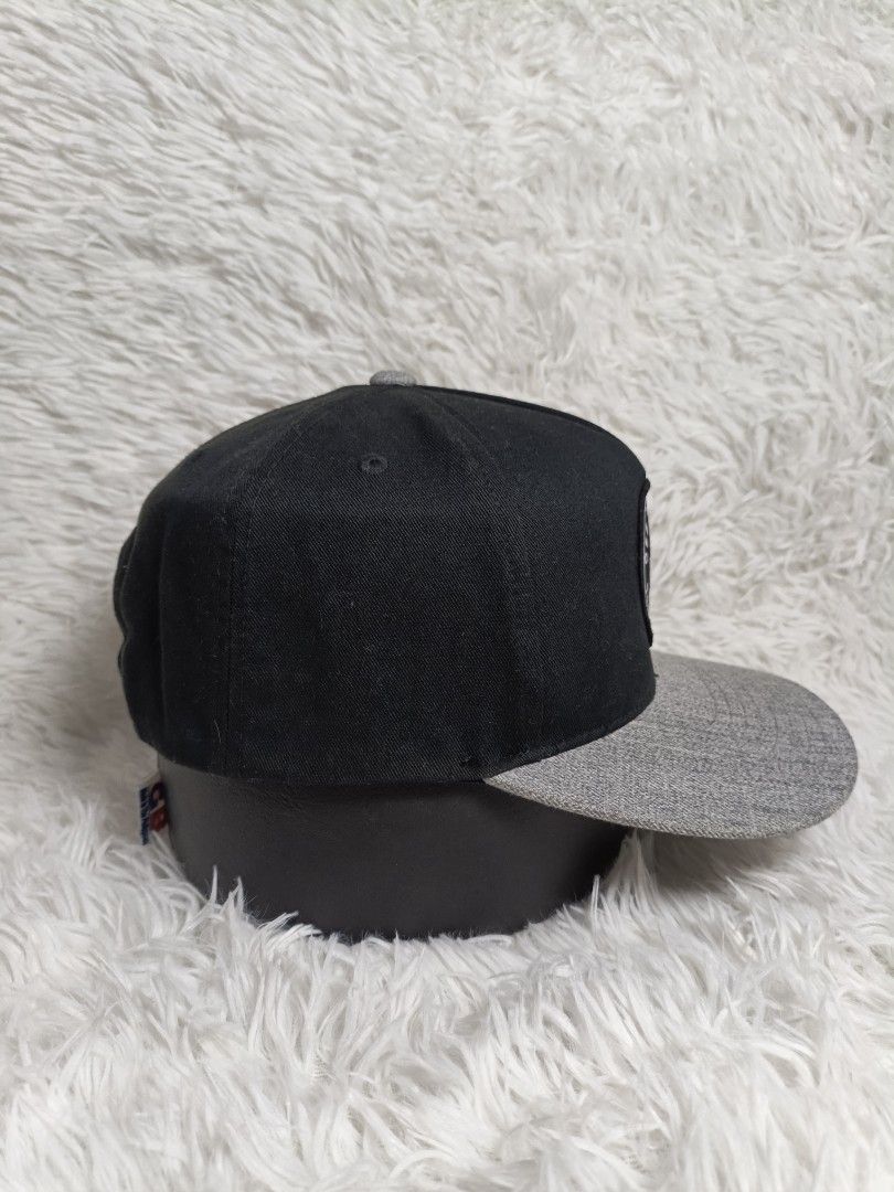 Vans Off The Wall Snapback Cap Black Grey (Category: Caps & Hats) located in Imus. Submitted by grindhouse.thriftshop (Listing ID 1466123425, Image 2). Description: - Brand: Vans - Style: Snapback hat - Colors: Black crown with grey heather flat brim - Details: Round woven logo patch on front, adjustable plastic strap closure with small Vans tag - Condition: Clean interior lining with internal taping intact - Mode of Transaction: Shipping or Pick