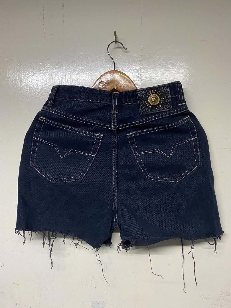 Versace Jeans Couture Dark Denim Shorts (Category: Shorts) located in Pasig City. Submitted by jstnisidor81288 (Listing ID 1466103188, Image 2). Description: - Brand: Versace Jeans Couture - Color: Dark blue denim with contrast white stitching - Fit: High-waisted with gold-tone logo hardware - Details: Signature leather logo patch on rear waistband, front and rear pockets - Hem: Distressed raw hem with frayed fringe threads - Style: Heavy vintage