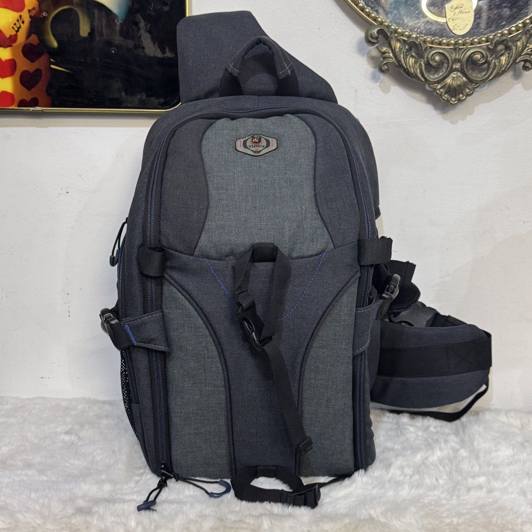 Victory Grey Camera Backpack with Adjustable Dividers (Category: Camera Bags & Carriers) located in Rizal. Submitted by houseofbell (Listing ID 1466150370, Image 2). Description: - Brand: Victory - Color: Grey and dark grey with a small compass logo patch - Storage: Fully opening main compartment with customizable padded velcro dividers - Pockets: Multiple exterior zippered pockets and mesh side pockets - Comfort: Breathable padded single-strap s