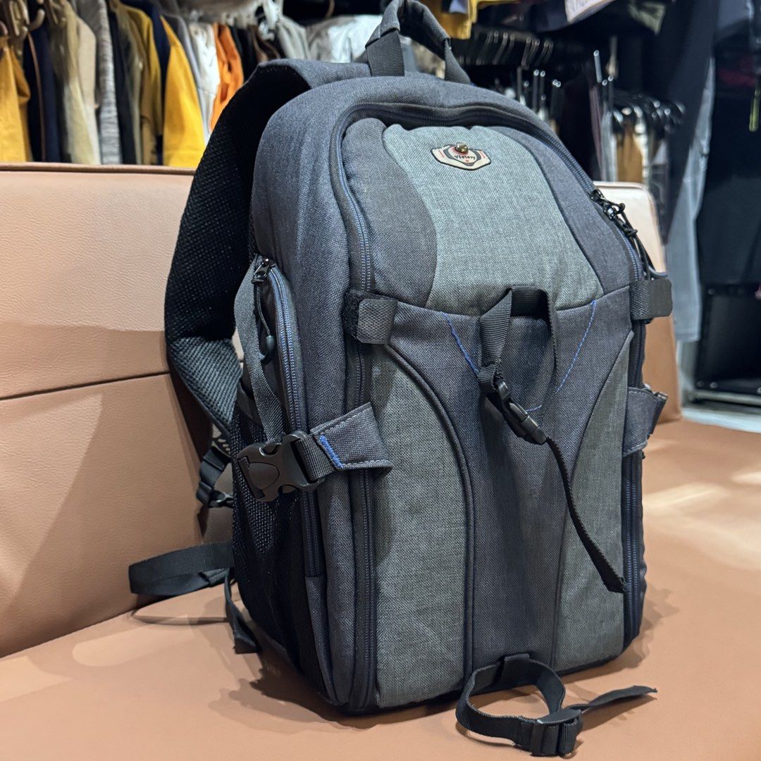 Victory Grey Camera Backpack with Adjustable Dividers (Category: Camera Bags & Carriers) located in Rizal. Submitted by houseofbell (Listing ID 1466150370, Image 1). Description: - Brand: Victory - Color: Grey and dark grey with a small compass logo patch - Storage: Fully opening main compartment with customizable padded velcro dividers - Pockets: Multiple exterior zippered pockets and mesh side pockets - Comfort: Breathable padded single-strap s