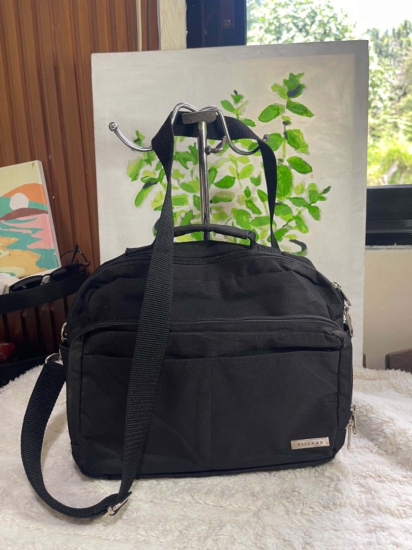Villand Black sling Bag (Category: Cross-body Bags) located in Naawan. Submitted by twilly.apparel2 (Listing ID 1465978578, Image 1). Description: - issue sa loob Brand: Villand - Color: Solid black canvas with silver hardware - Storage: Multiple front zipped compartments for small items - Carrying Options: Sturdy top handle and long adjustable strap - Best For: Daily commutes, work, and everyday use.