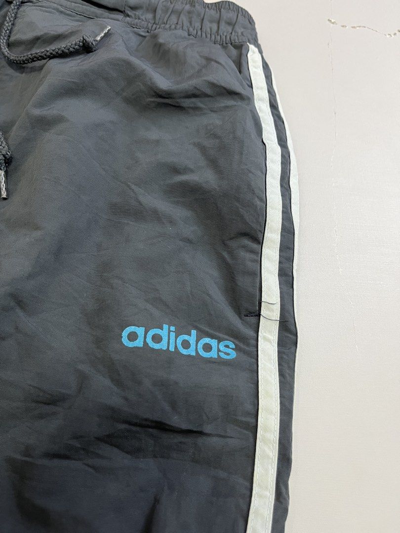 Vintage Adidas Grey Capri (Category: Joggers) located in Mabalacat. Submitted by aas_thriftfings (Listing ID 1465991326, Image 3). Description: - Brand: Adidas - Style: Windbreaker Track Pants - Color: Grey with white side stripes and light blue logo - Size: L (175/82A measurements) - Features: Elastic waistband with adjustable drawstring, comfortable inner mesh lining - Origin: Made in China.