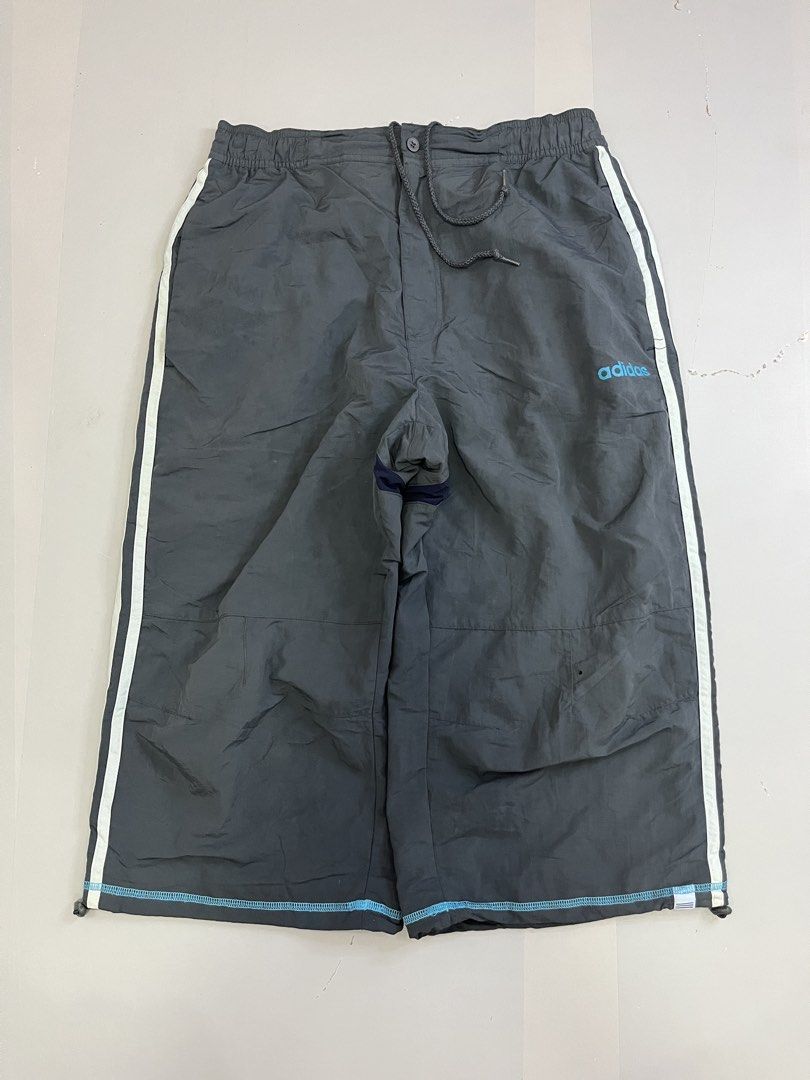 Vintage Adidas Grey Capri (Category: Joggers) located in Mabalacat. Submitted by aas_thriftfings (Listing ID 1465991326, Image 1). Description: - Brand: Adidas - Style: Windbreaker Track Pants - Color: Grey with white side stripes and light blue logo - Size: L (175/82A measurements) - Features: Elastic waistband with adjustable drawstring, comfortable inner mesh lining - Origin: Made in China.
