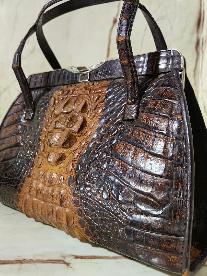 Vintage Brown Crocodile Leather Handbag (Category: Clutches) located in Tarlac. Submitted by jeremiah.curator.2026 (Listing ID 1466116551, Image 2). Description: - Material: Genuine crocodile leather with distinct hornback texture - Color: Rich brown gradient - Closure: Secure silver-tone metal top clasp - Carry: Dual top handles for hand or forearm wear - Design: Structured retro silhouette with a flat base for stability.