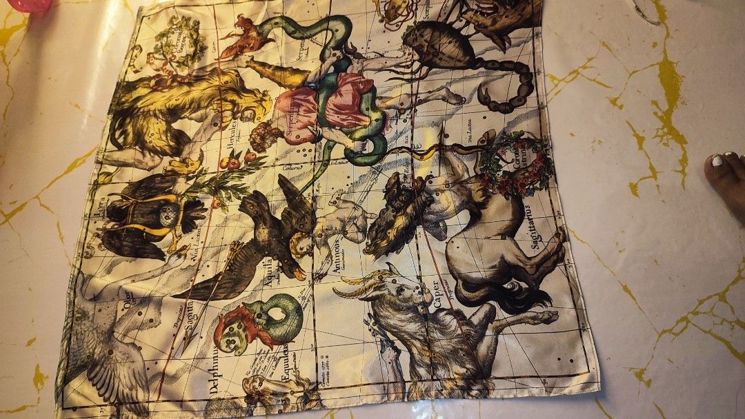 Vintage Celestial Constellation Map Silk Scarf (Category: Scarves) located in Manila. Submitted by anez06 (Listing ID 1466095872, Image 2). Description: - Vintage celestial map scarf featuring constellations including Hercules, Sagittarius, and Scorpius - Cream background with rich, multi-color illustrations and detailed grid lines - Smooth fabric texture with neat, finished stitched edges - Square format, perfect for versatile styling.