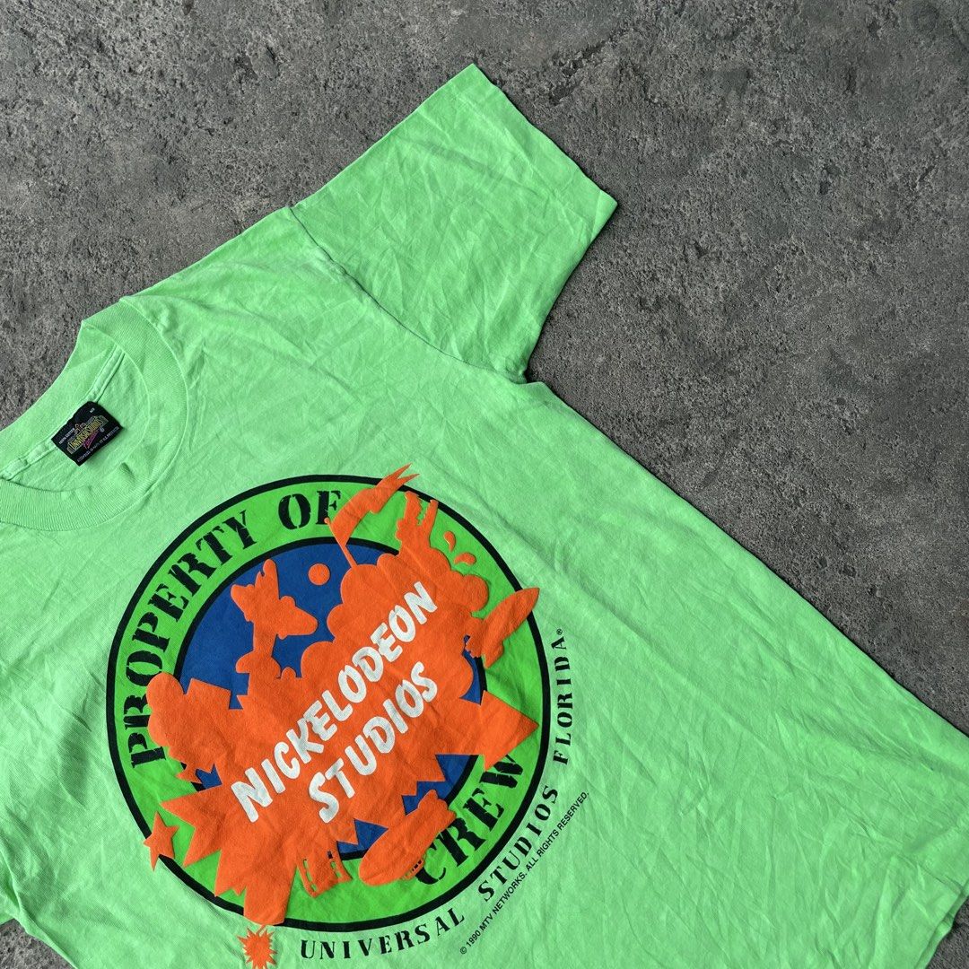 Vintage Nickelodeon Studios Universal Studios Florida Crew T-Shirt (Category: Tshirts & Polo Shirts ) located in Polangui. Submitted by b0ssl00ts (Listing ID 1465961829, Image 3). Description: - Authentic 1990 vintage Nickelodeon Studios Universal Studios Florida crew tee - Color: Bright green with a large, bold chest graphic - Size: Medium (Universal Studios collar tag) - Material: Soft, comfortable cotton feel - Condition: Rare piece of 90s TV 