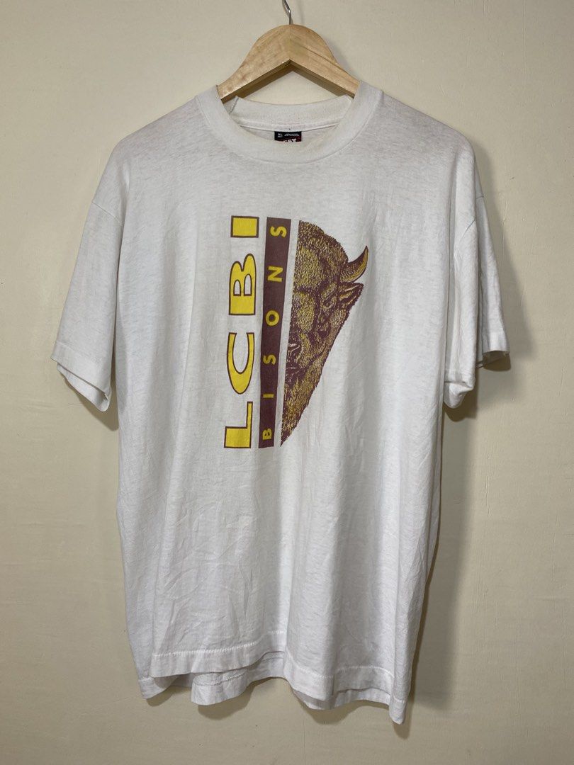 VINTAGE,(LCBI bisons) t-shirt (Category: Tshirts & Polo Shirts ) located in Cavite. Submitted by jc_thrift95 (Listing ID 1466089336, Image 1). Description: - Vintage white graphic t-shirt featuring a “LCBI Bisons” bison head graphic on the front. - Made in USA - Single stitch all the way - L- 28 inch - W- 23 inch - Color rate 8/10 (need wash) - See pictures details for dimes.
