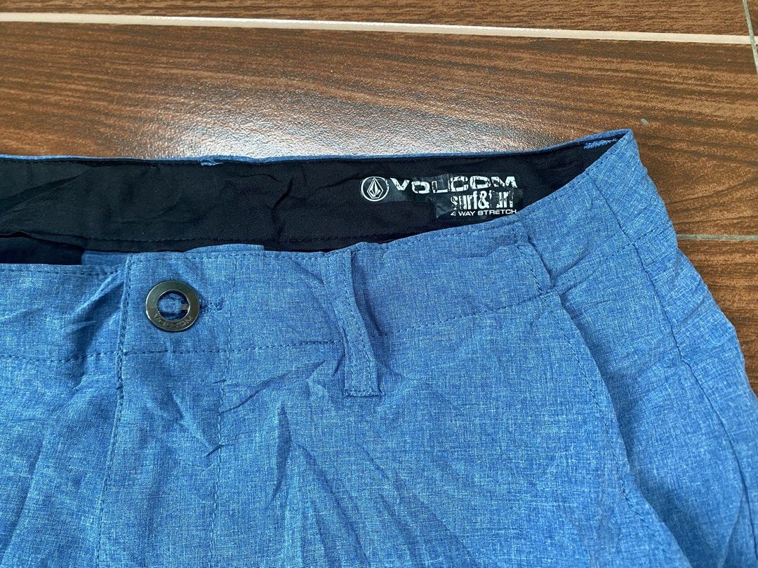 Volcom Surf N Turf 4-Way Stretch Blue Shorts (Category: Shorts) located in Cebu City. Submitted by thriftpherskzai (Listing ID 1466074480, Image 3). Description: - Brand: Volcom - Color: Blue - Material: Lightweight 4-way stretch fabric for maximum comfort - Closure: Button waist with belt loops - Pockets: Right zippered back pocket with Volcom logo patch and left buttoned back pocket - Details: Subtle Volcom stone logo rubber print near the hem 