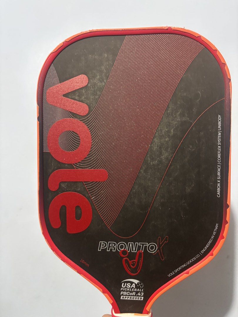 Vole Pronto X 16mm Pickleball Paddle (Category: Racket and Ball Sports) located in Mandaluyong City. Submitted by jb_toys (Listing ID 1465984149, Image 3). Description: - Model: Vole Pronto X Pickleball Paddle - Thickness: 16mm with unibody construction - Surface & Core: Carbon X surface with coreflex system - Certification: USA Pickleball PBCor.43 approved - Design: Black face, red graphics, and orange edge guard - Handle: Wrapped orange cushion