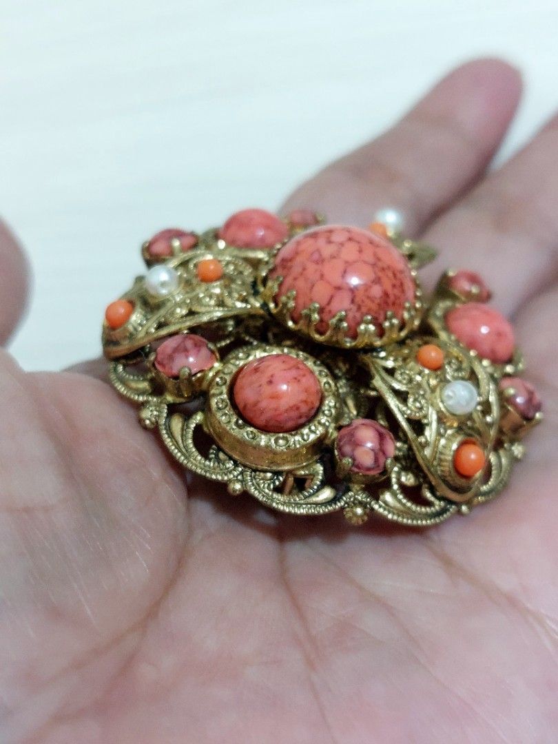 Vtg Brass Filigree Brooch (Category: Luxury Accessories) located in Muntinlupa City. Submitted by sakurambo_des (Listing ID 1466079156, Image 3). Description: Vintage Brass Filigree Brooch featuring speckled coral-colored art glass cabochons and simulated pearl accents, commonly associated with mid-century in West Germany. Check pictures for measurement. In very good condition..