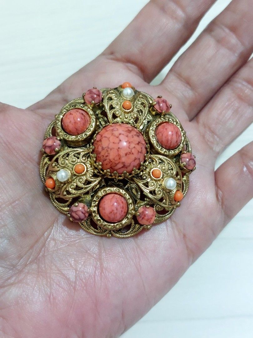 Vtg Brass Filigree Brooch (Category: Luxury Accessories) located in Muntinlupa City. Submitted by sakurambo_des (Listing ID 1466079156, Image 2). Description: Vintage Brass Filigree Brooch featuring speckled coral-colored art glass cabochons and simulated pearl accents, commonly associated with mid-century in West Germany. Check pictures for measurement. In very good condition..